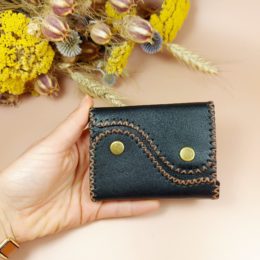 porte-monnaie porte-cartes en cuir noir dans la main