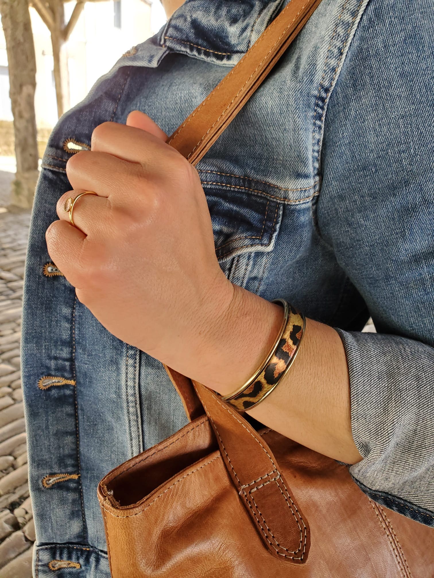 bracelet manchette jonc cuir léopard porté au bras d'une femme